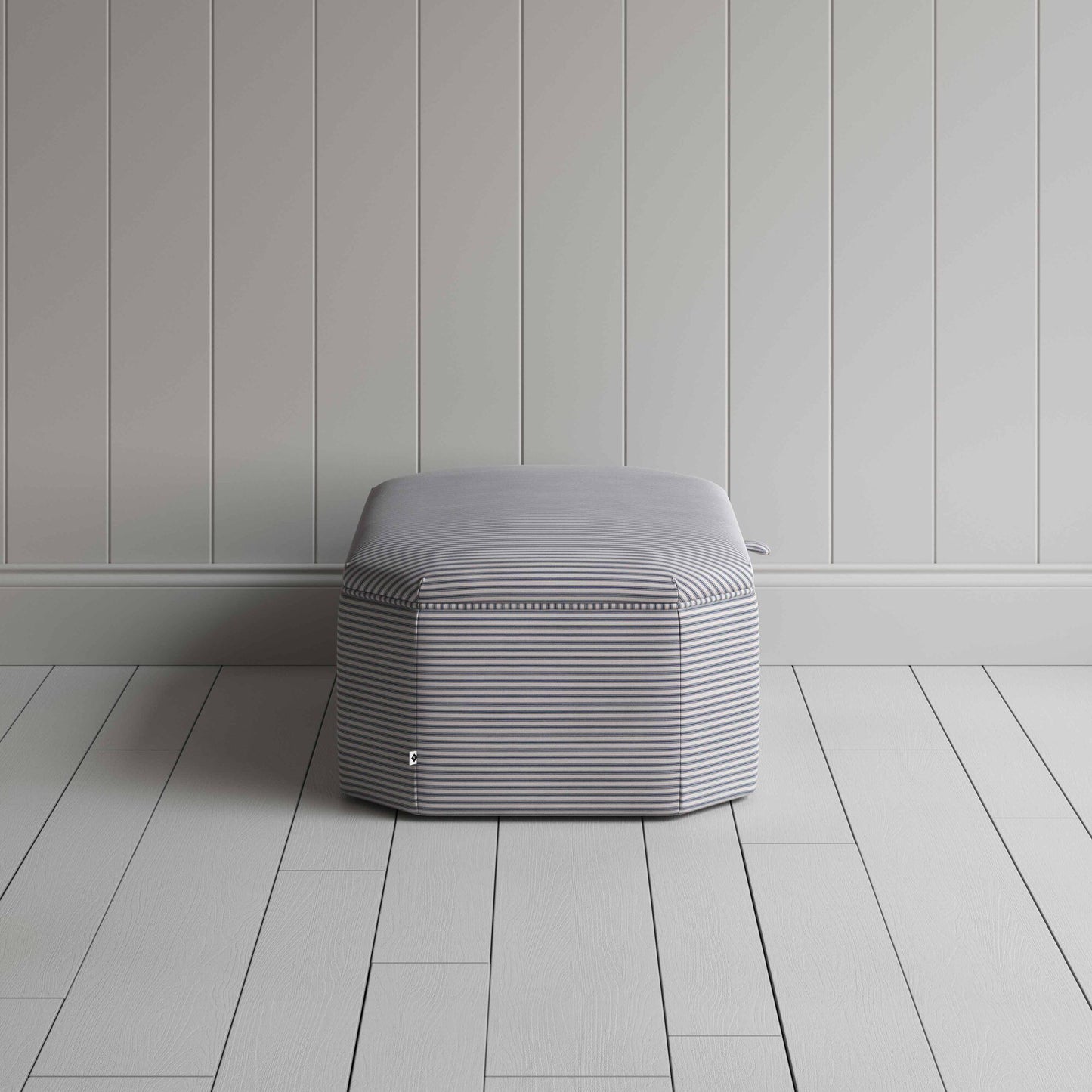 Stylish grey ottoman against white flooring.