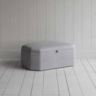  Stylish grey ottoman against white flooring. 