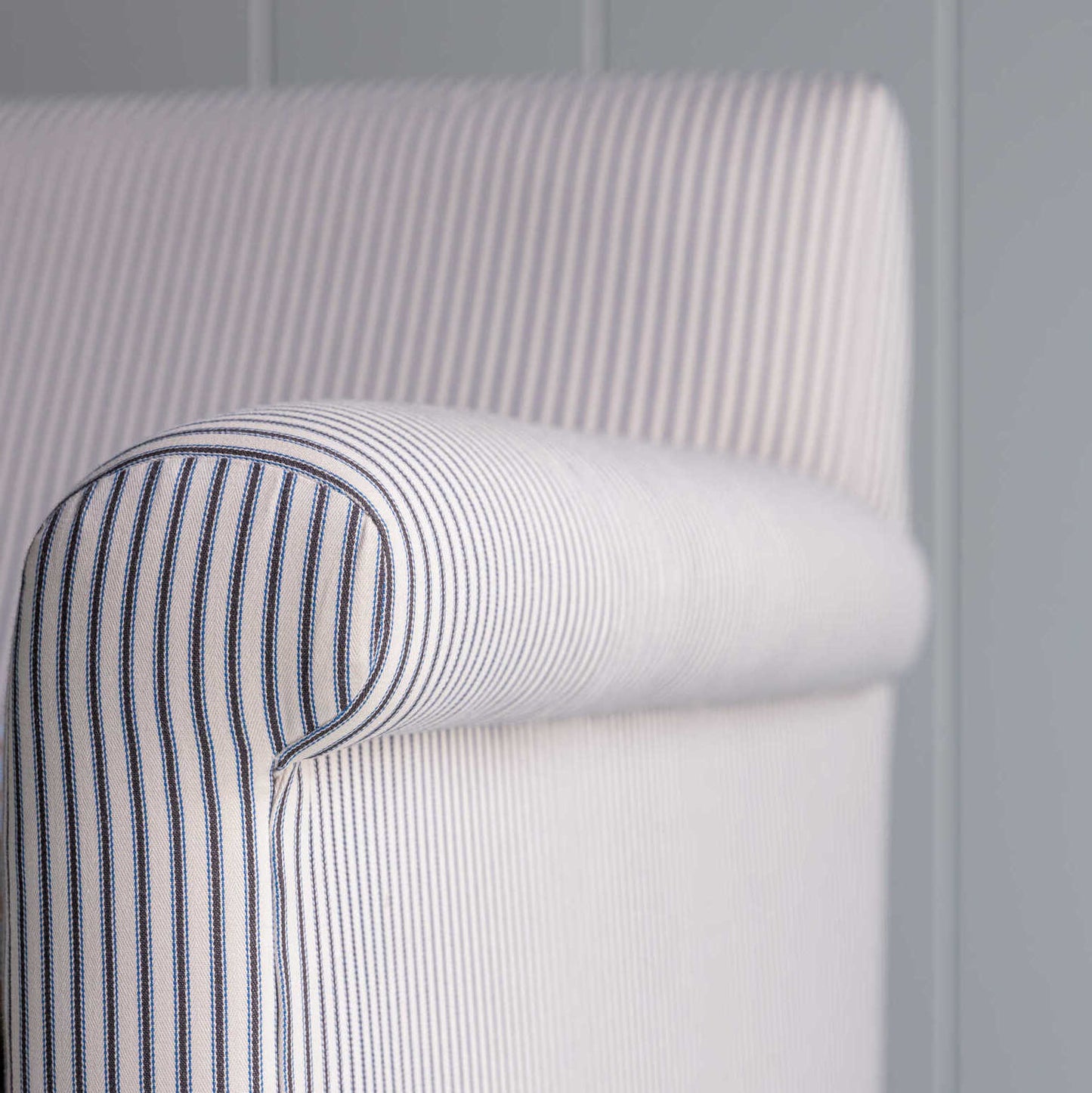 Close-up of the arm design of the Idler 2-seater sofa in Ticking Cotton Chocolate Navy fabric by NiX.