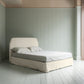 King-size upholstered bed by NiX in laidback linen dove with a kick pleat valance, shown in a complete side view.