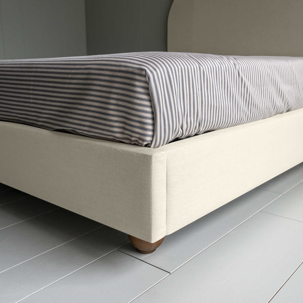  Upholstered Bed in Laidback Linen Dove without Valance, showcasing the edge design and a neatly tucked-in bedsheet. 