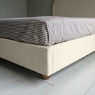  Upholstered Bed in Laidback Linen Dove without Valance, showcasing the edge design and a neatly tucked-in bedsheet. 