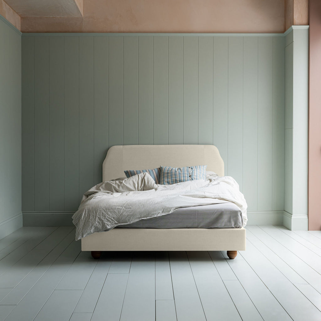  Dream Ticket upholstered bed in laidback linen dove without a valance, shown in a front view with blankets and pillows. 