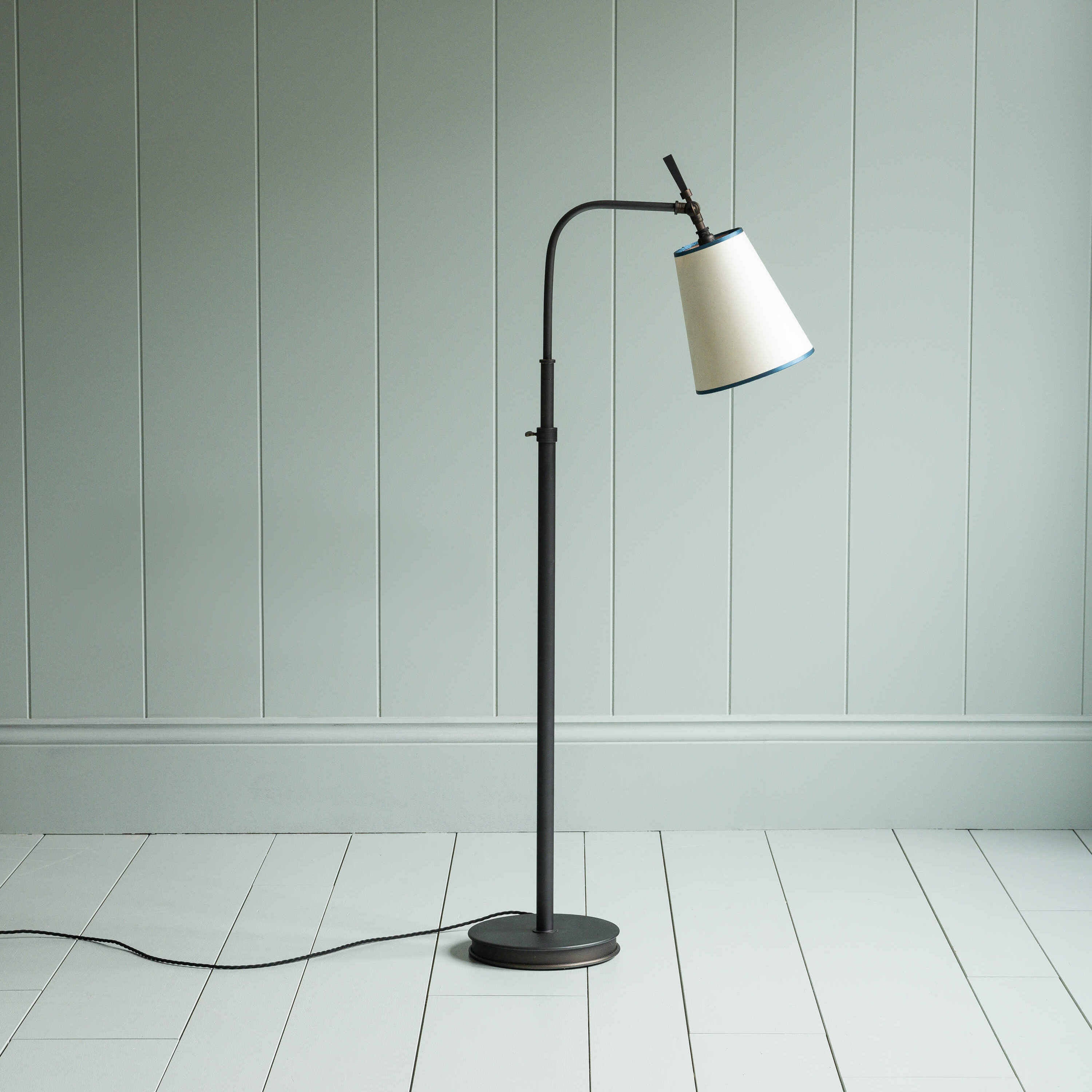  Modern floor lamp with a white shade casting a warm light in the room. 