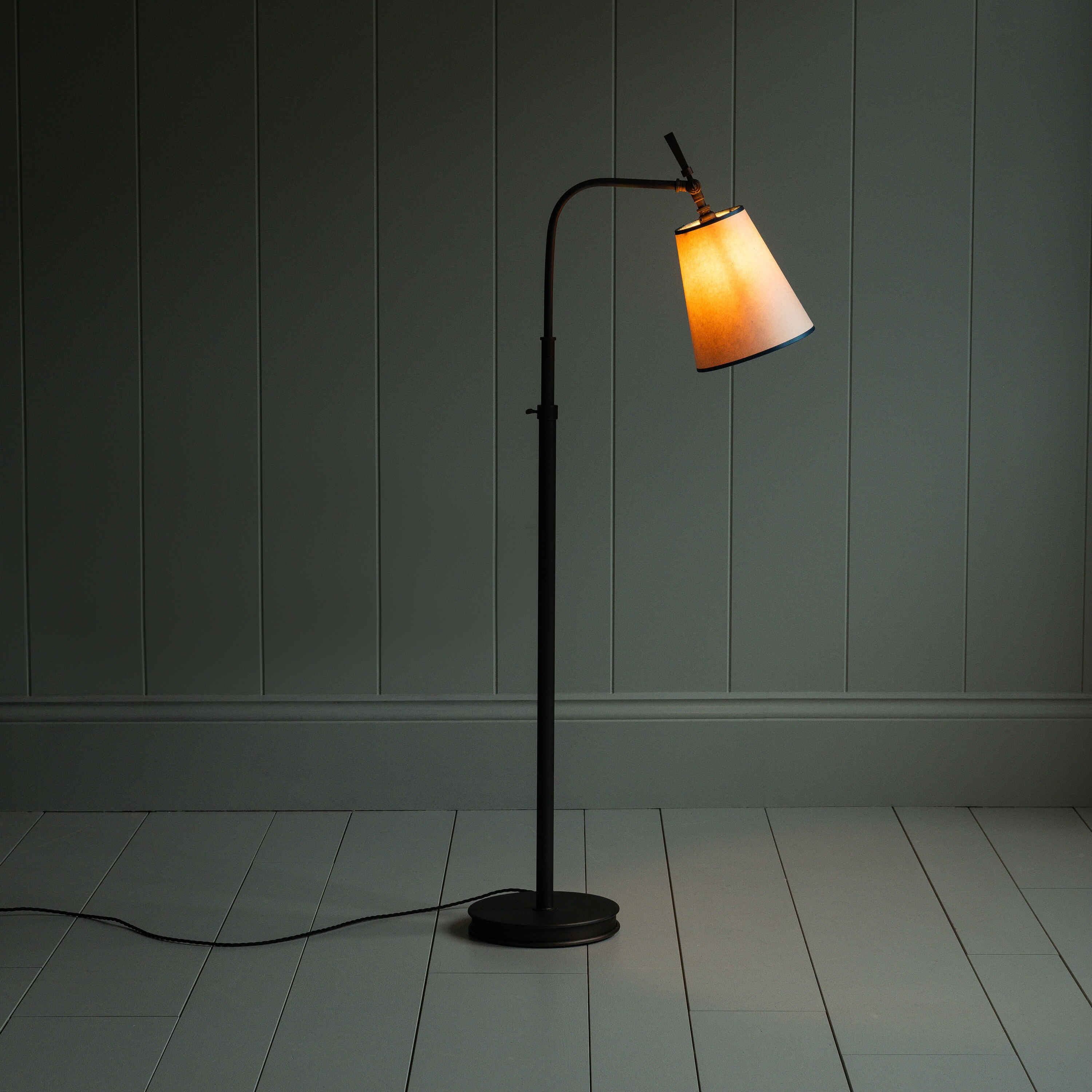  A lamp on a wooden floor in a room. 