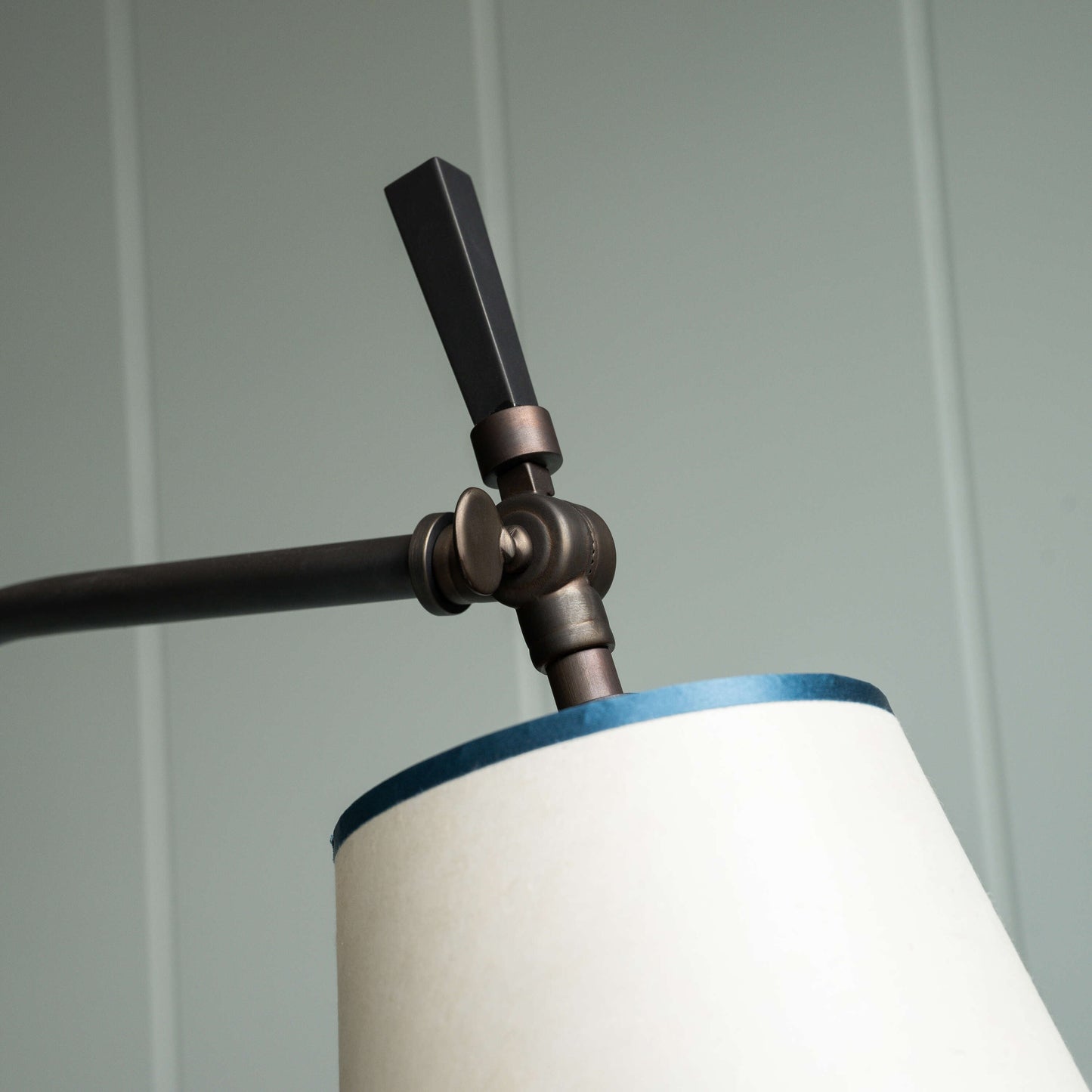 A lamp with a white shade and a black arm, providing stylish lighting for any room decor.