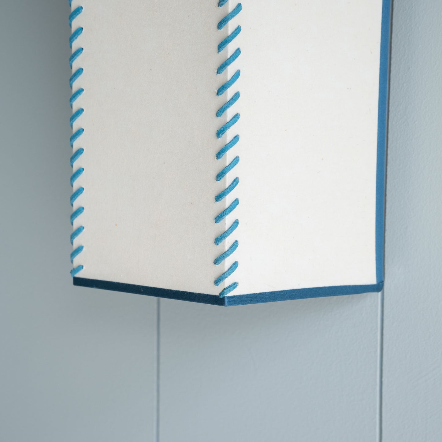 Stitch In Time Wall Light in Soft White with Peacock Blue Trim & Stitching, Design Closeup - NiX Lampshades