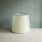 White lamp shade with blue stitching, adding a touch of color to any room decor.