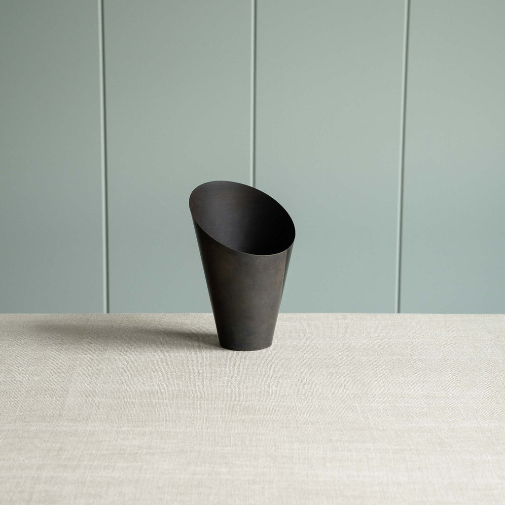  A black part of lamp against a green wall. 