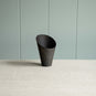  A black part of lamp against a green wall. 