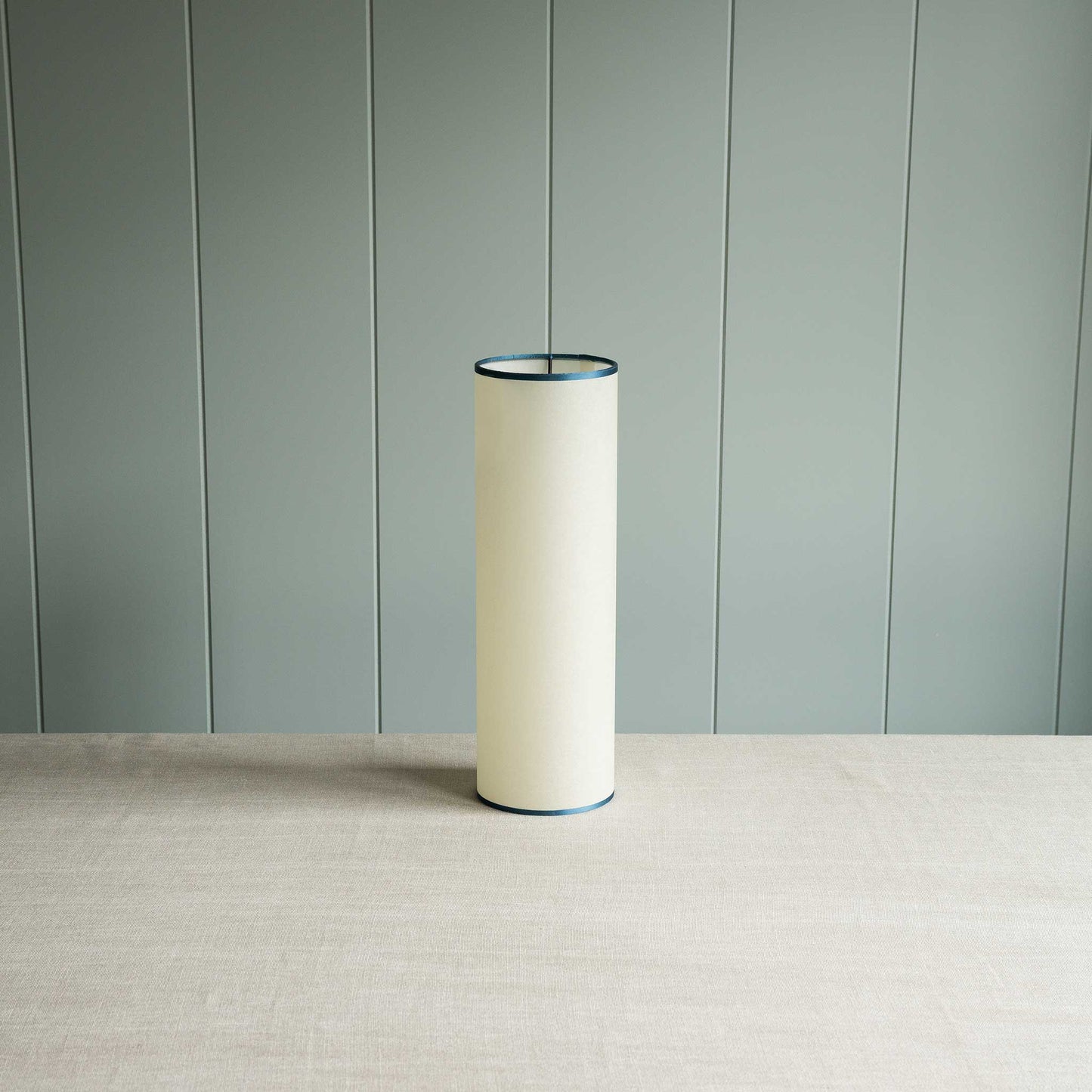 White lamp on table against green wall.