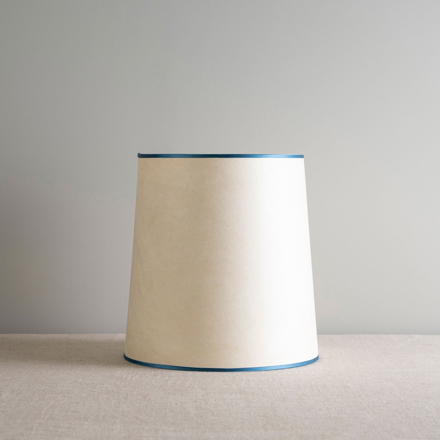 A white lamp with blue trim on a table, providing illumination in a room.