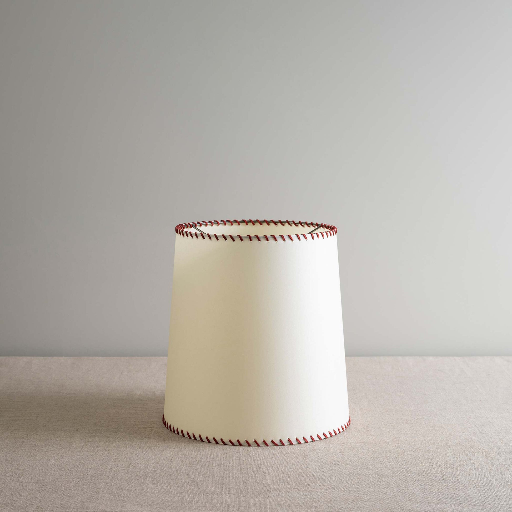  Modern white lamp featuring stylish red stitching for a touch of elegance.