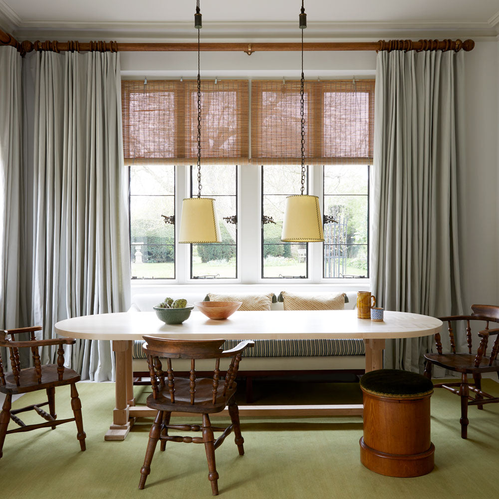 A cozy dining room with a wooden table and chairs, set for a meal with elegant tableware.