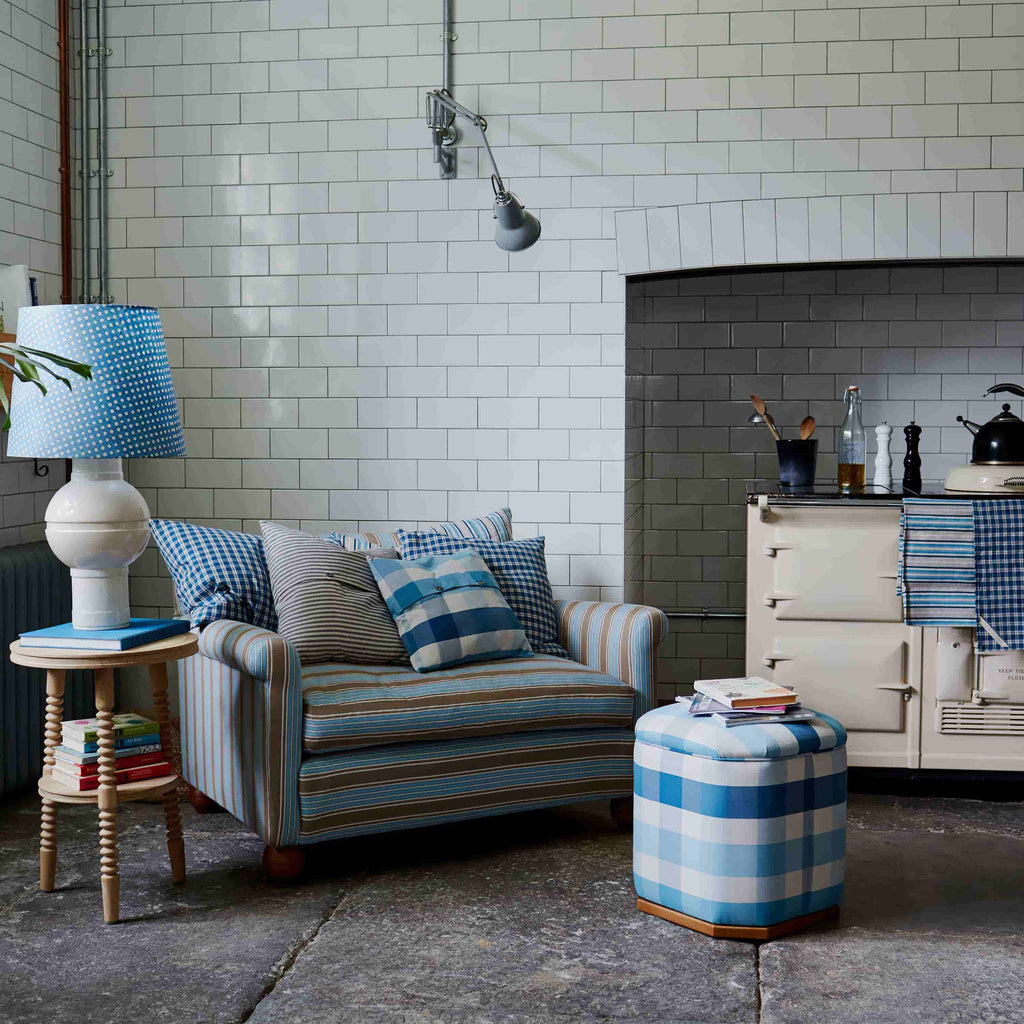  A cozy living room with a comfortable couch, a stylish lamp, a sleek table, and a decorative lampshade. 