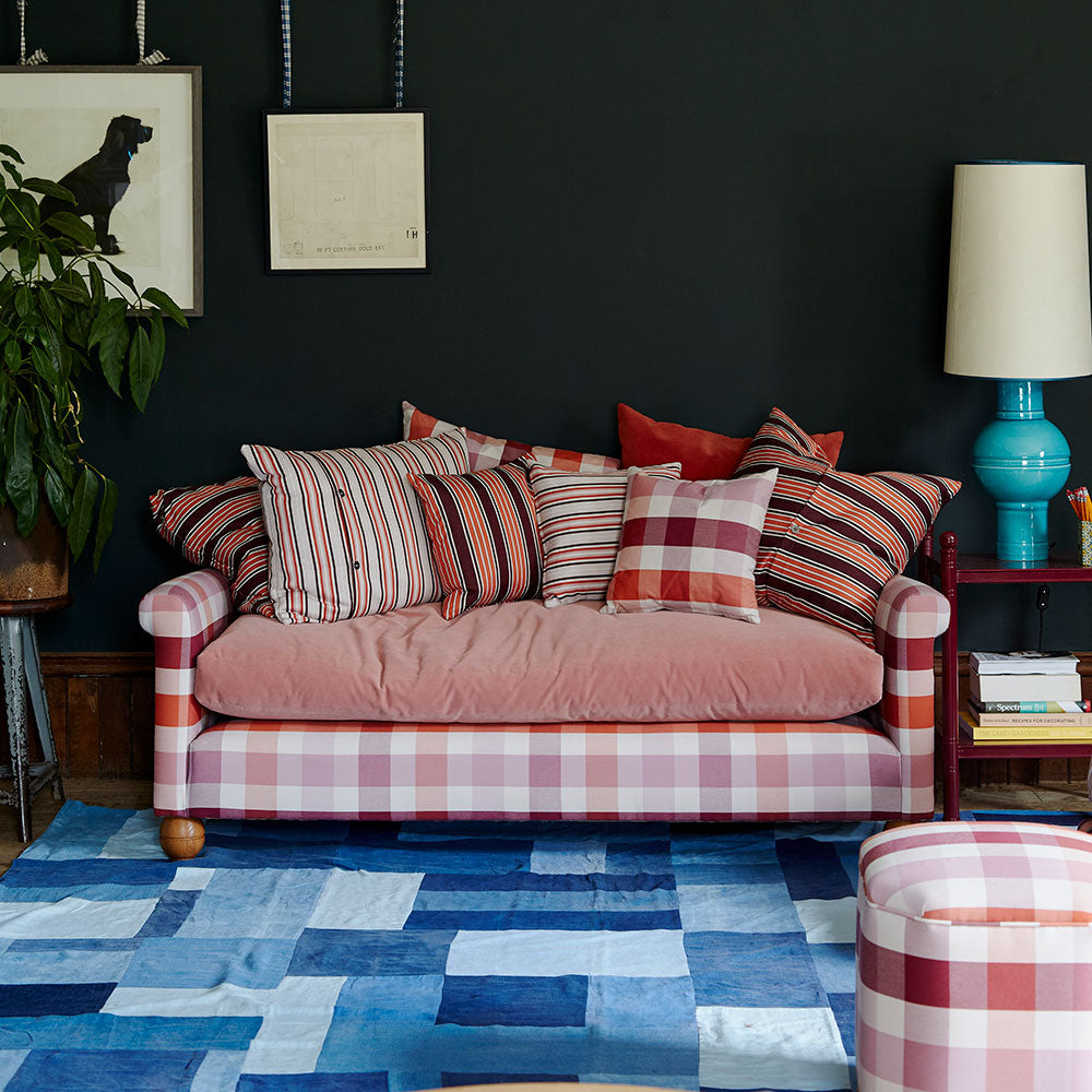  Stylish sofa designed by Nicola Harding & Co., elegantly paired with cushions in a beautifully arranged living room. 