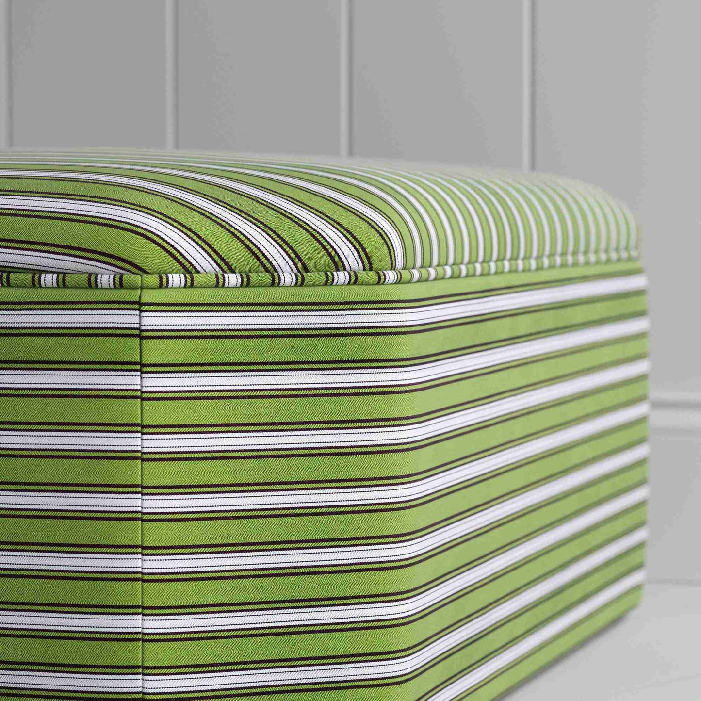 Zoomed stylish green and white striped ottoman, ideal for enhancing the aesthetic of your living space.