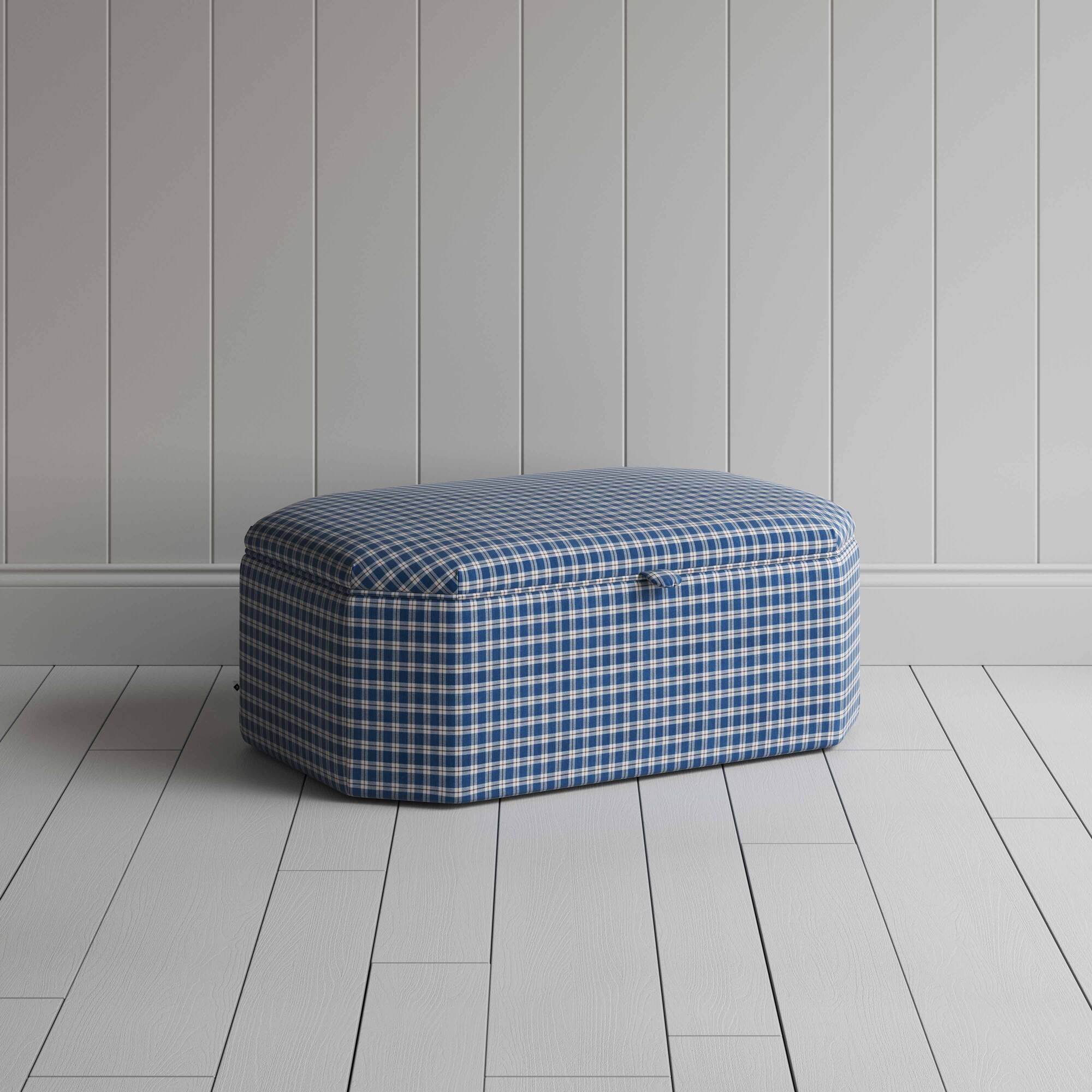  Blue and white checkered ottoman on wooden floor. 