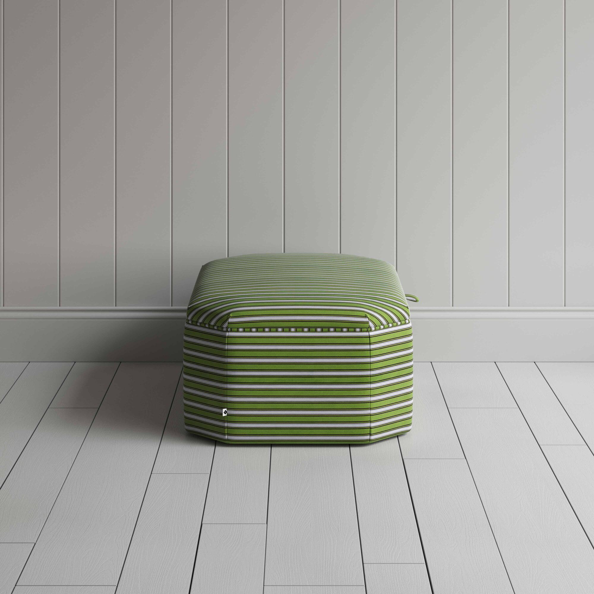  A striped green and white ottoman on a wooden floor, adding a touch of color and comfort to the room. 