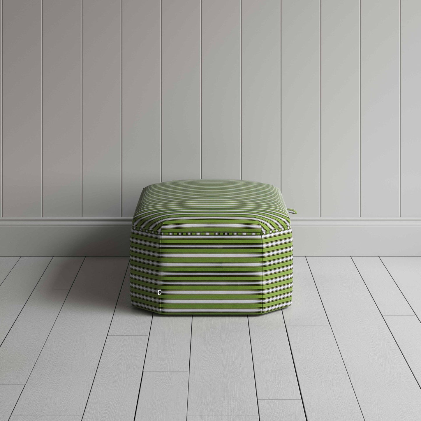 A striped green and white ottoman on a wooden floor, adding a touch of color and comfort to the room.