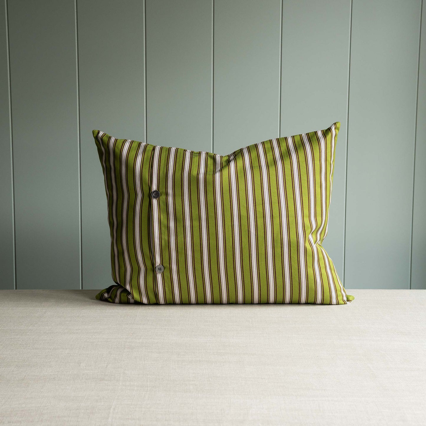 A green and white striped pillow on table.