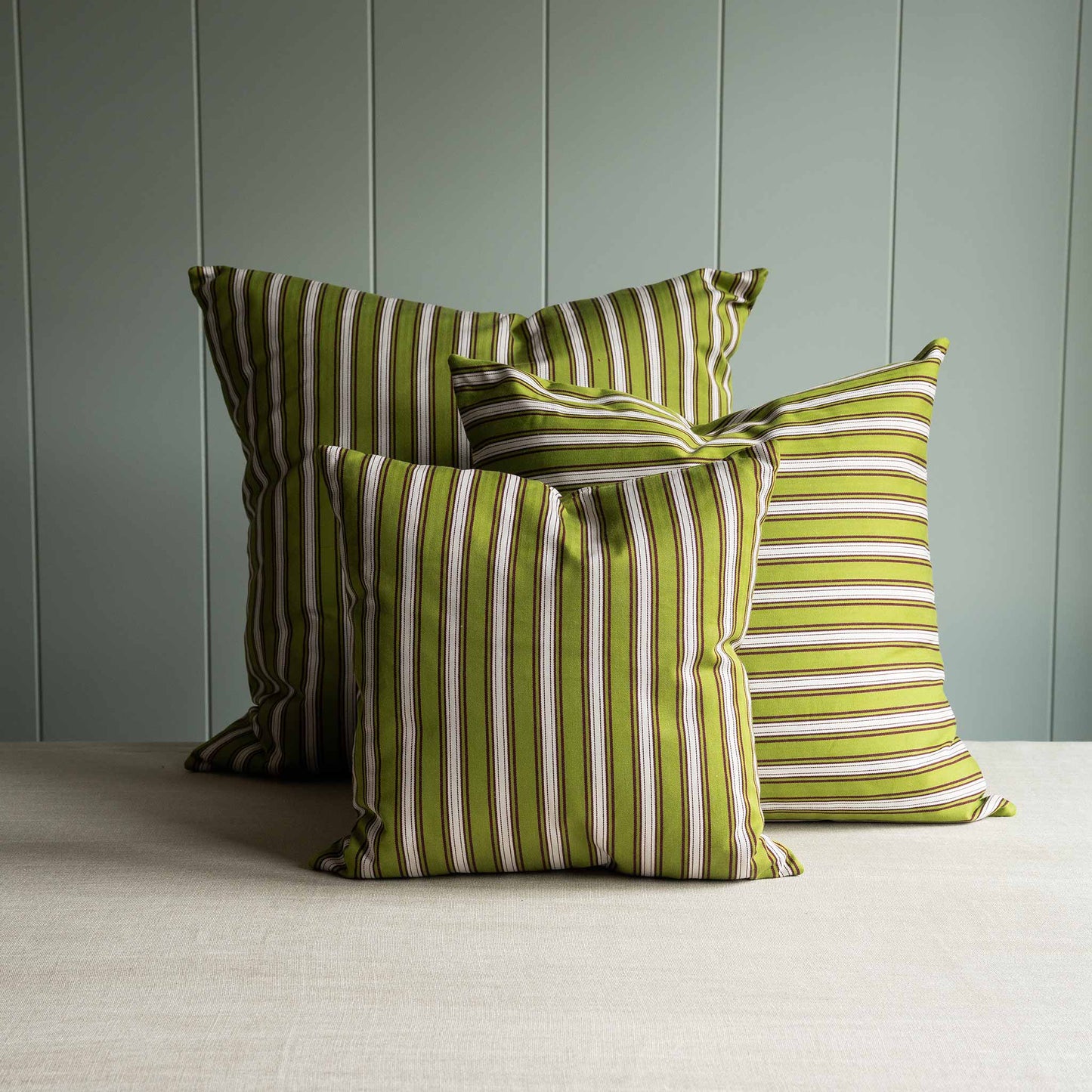 Three green and white striped pillows neatly arranged.