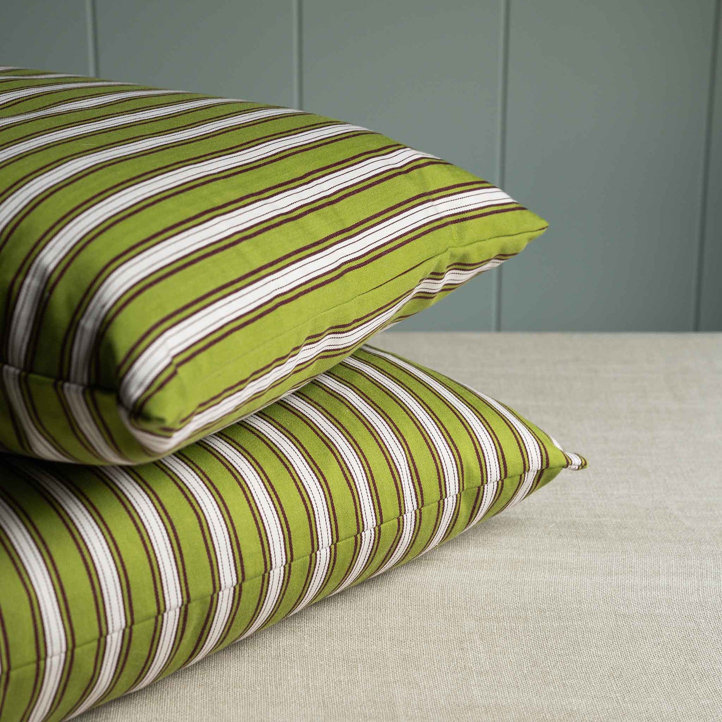 Two decorative cushions with striped green and white pattern.