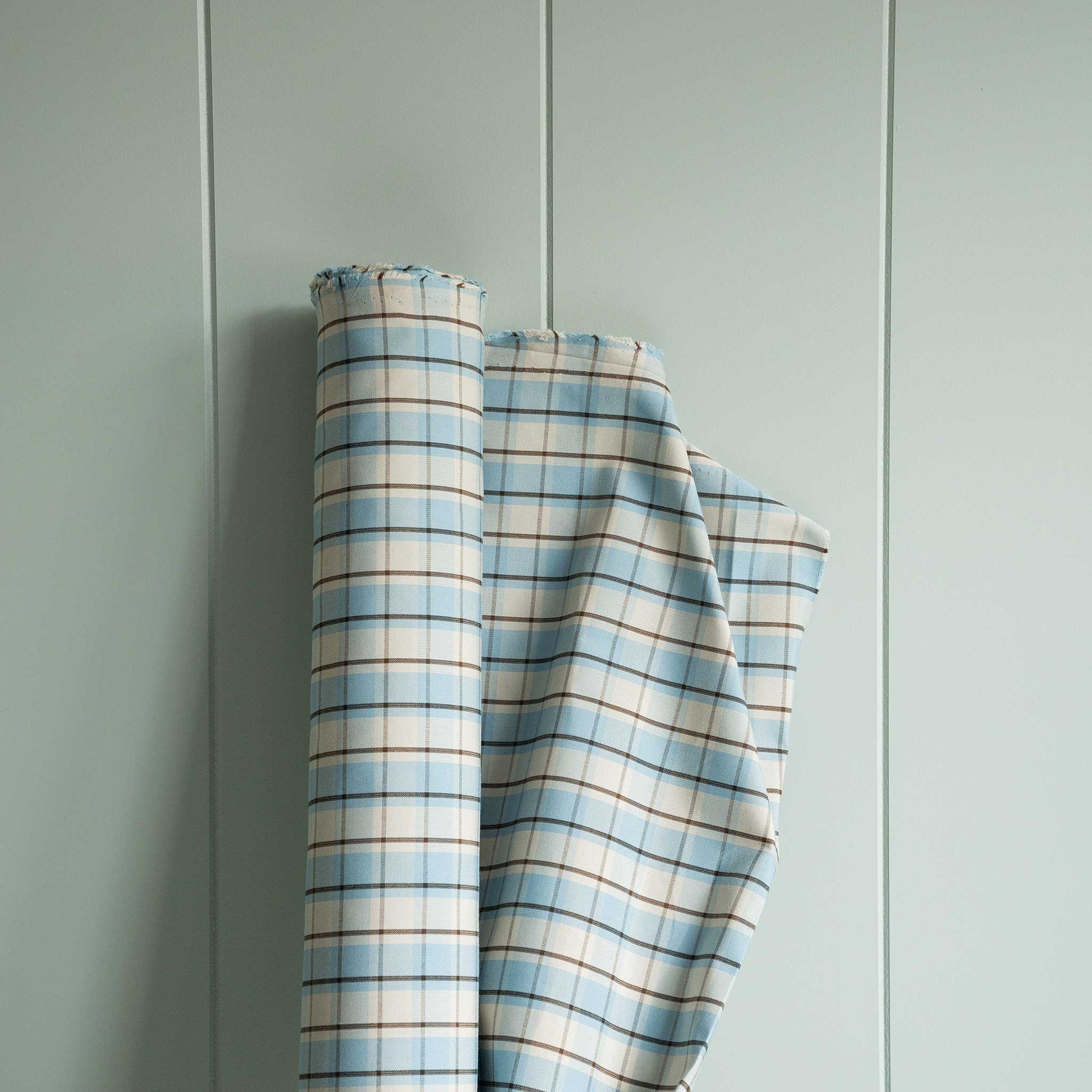 Blue and white plaid fabric displayed on wall.