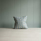 Decorative pillow featuring blue and white plaid design.