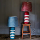  Humbug Striped Ceramic Table Lamps: Cherry Red & Warm White Base with Red Dotted Lampshade (on Stool), and Blue & Warm White Base with Blue Dotted Lampshade – Nicola Harding 