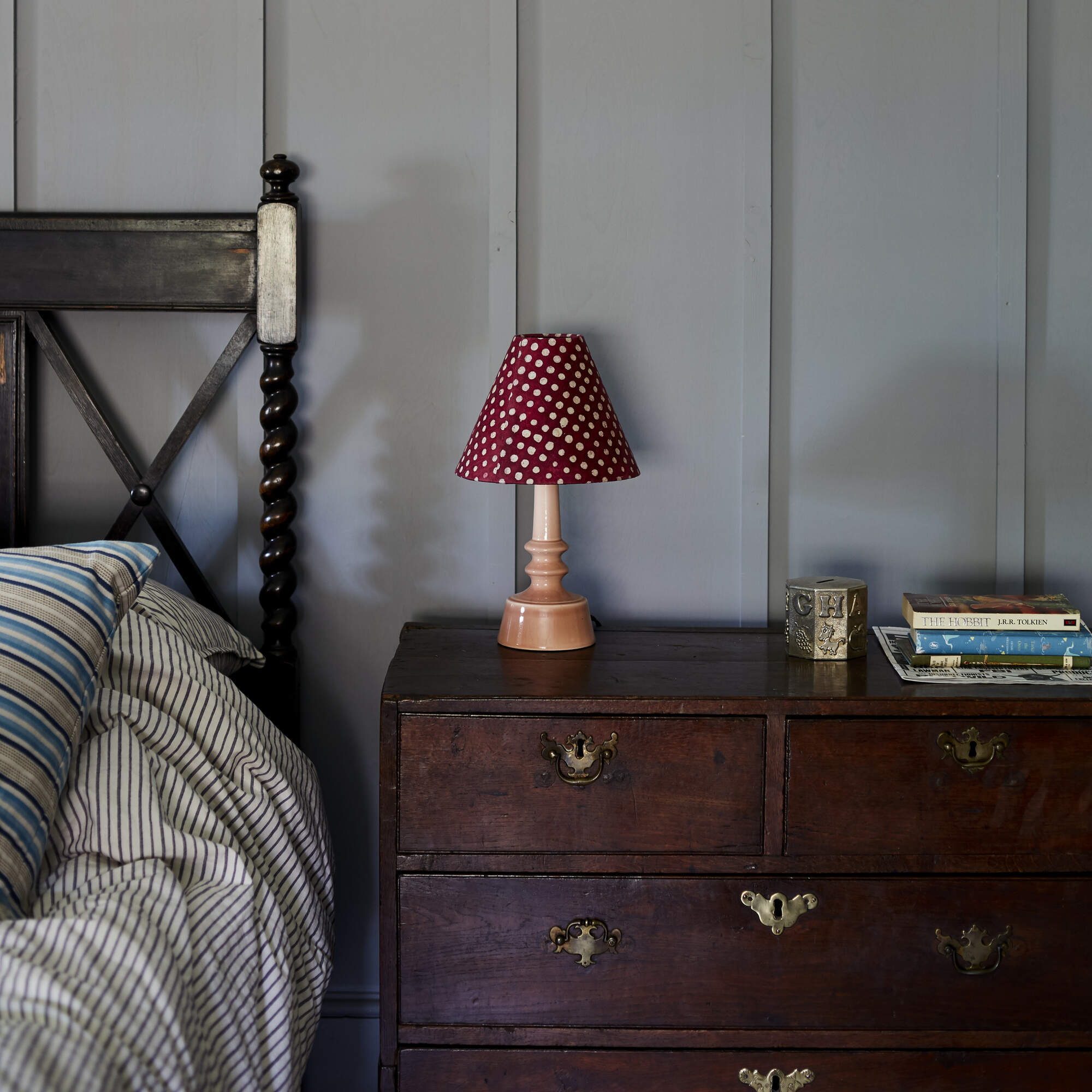  Ditsy Ceramic Table Lamp Base in Blush Pink, With Ditsy Classic Empire Lamp Shade in Dotty Maroon, On a Bed Side table With Couple of Books - By NiX 