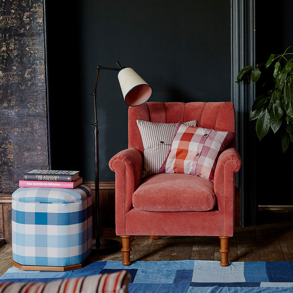  Elegant armchair paired with a floor lamp and ottoman, beautifully styled in a living room by Nicola Harding & Co. 