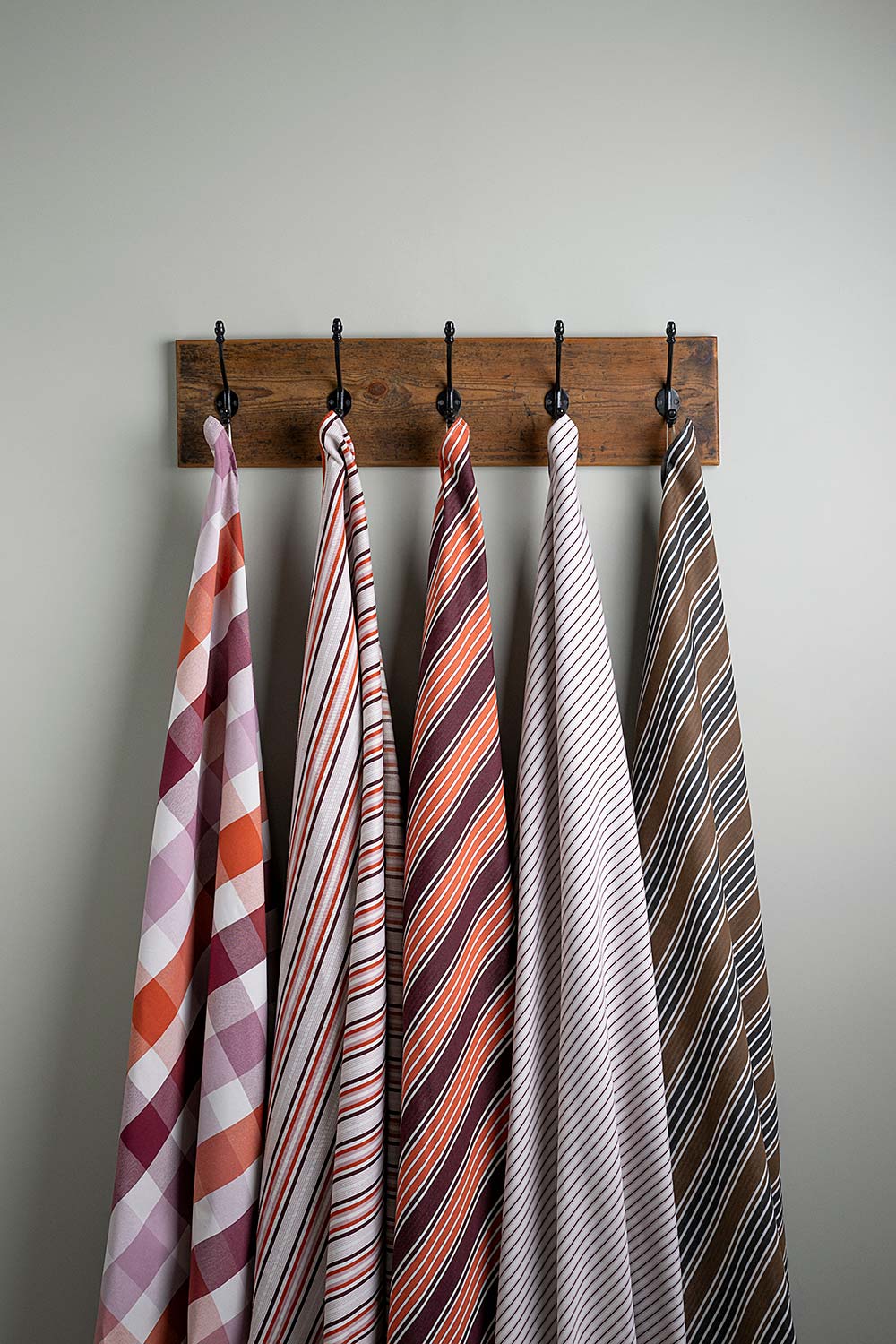  Cotton Fabric Swatches in Different Designs Hanging on Hooks – By NiX 