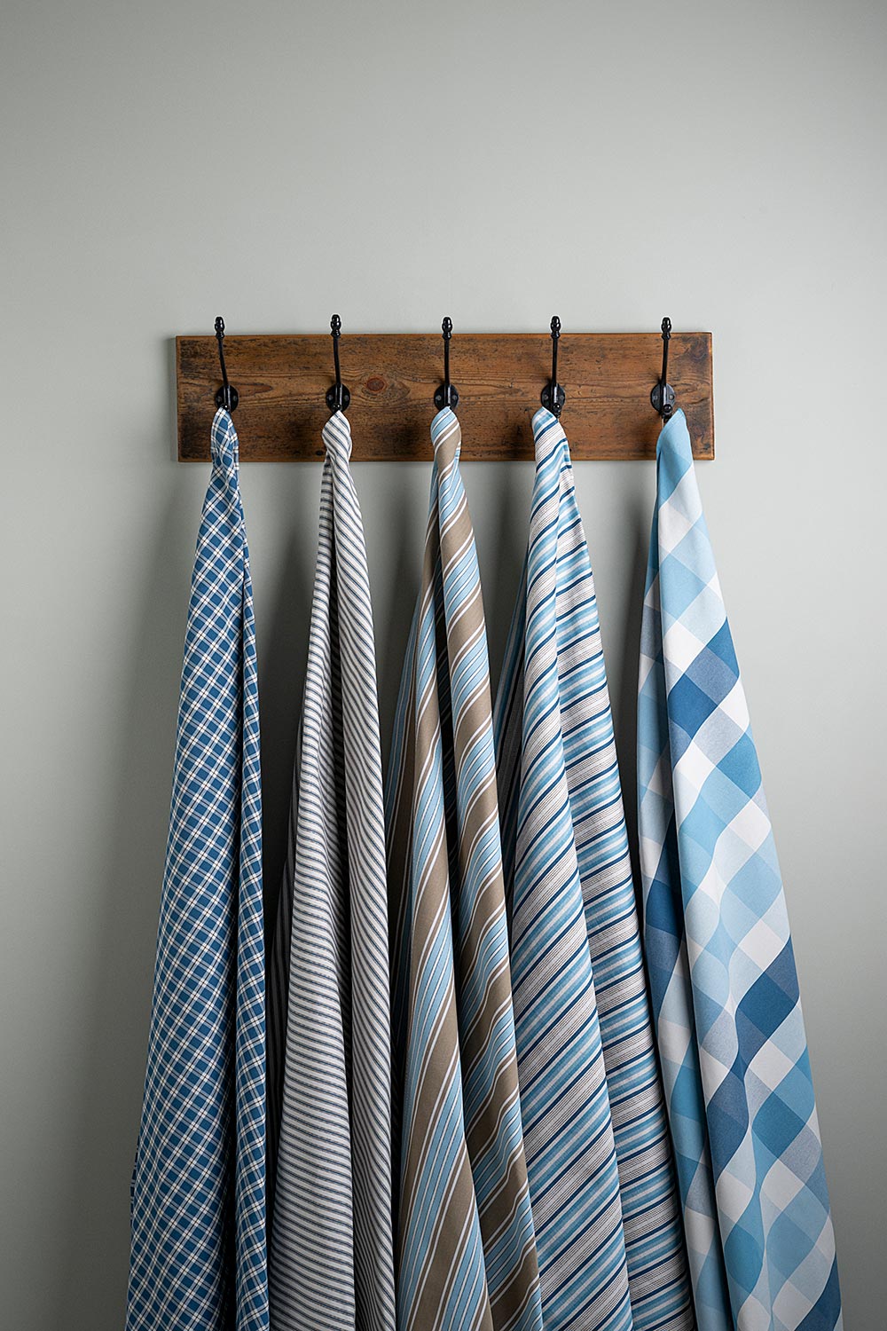  Cotton Fabric Swatches in Different Designs Hanging on Hooks – By NiX 